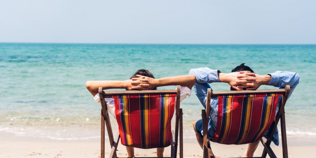 Twee mannen genieten vanuit een strandzetel van de zee