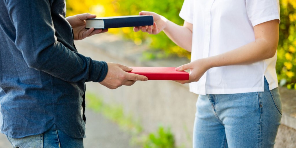 Man en vrouw wisselen boeken uit