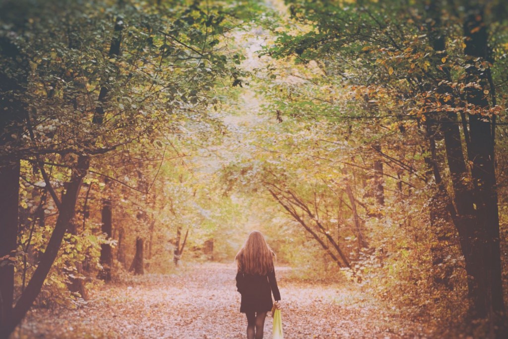 Vrouw wandelt alleen op een bospad