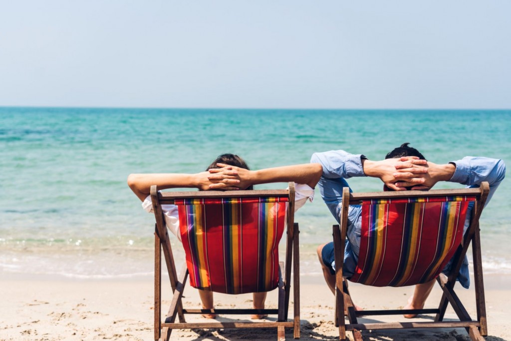 Twee mannen genieten vanuit een strandzetel van de zee