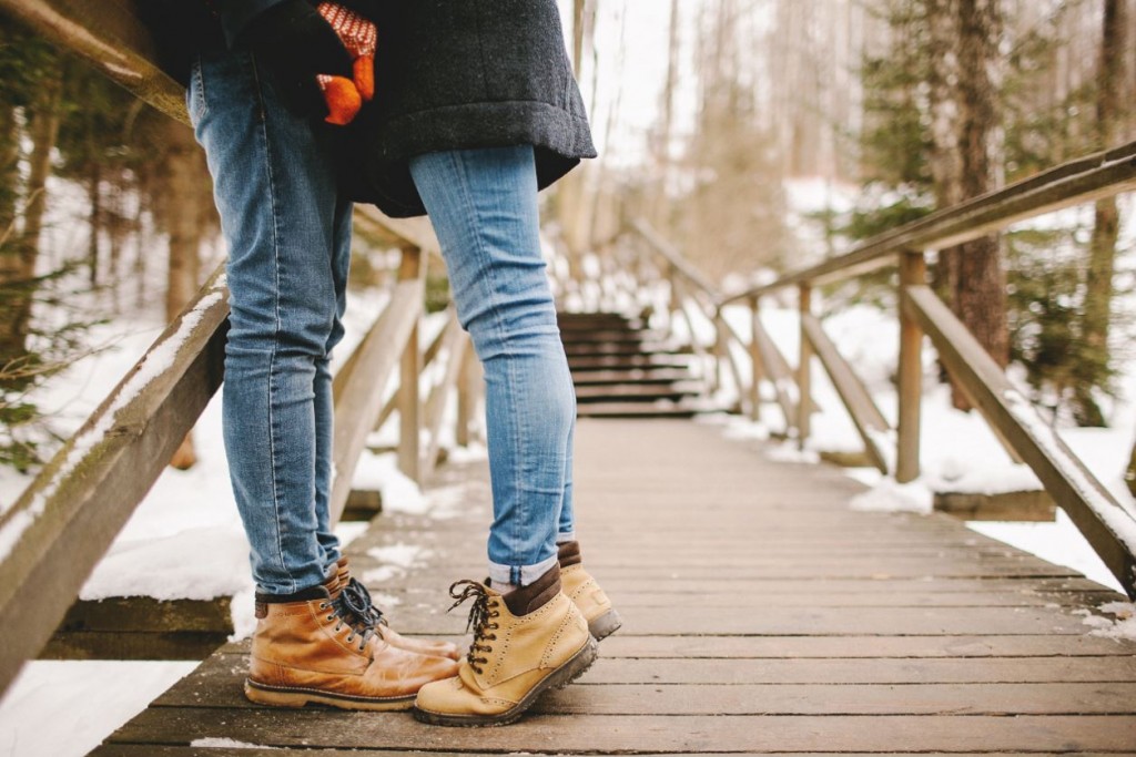 Koppel op een brug in een winters landschap. Enkel hun benen zijn zichtbaar.