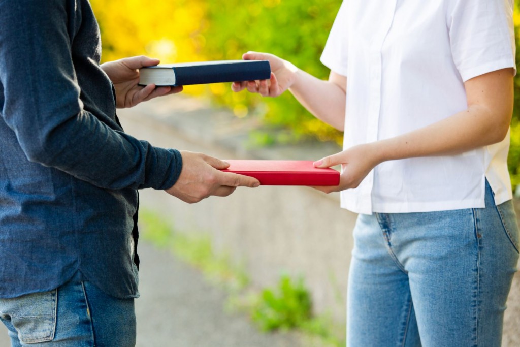 Man en vrouw wisselen boeken uit