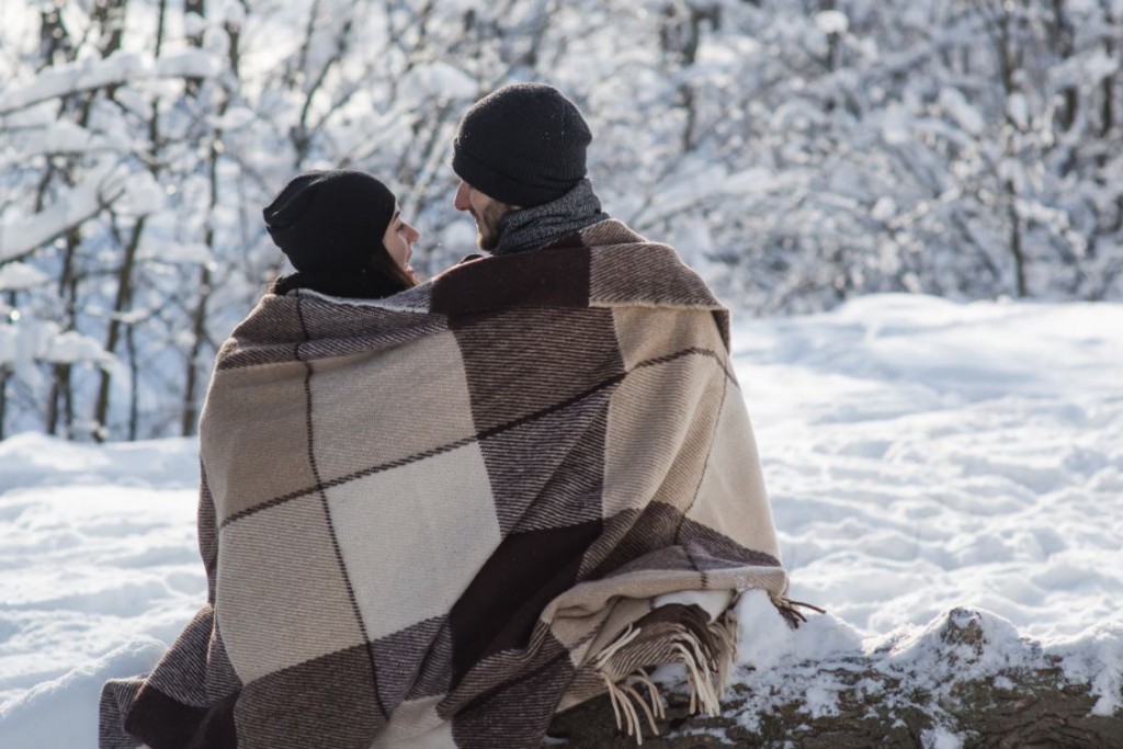 Koppel onder een deken in de sneeuw