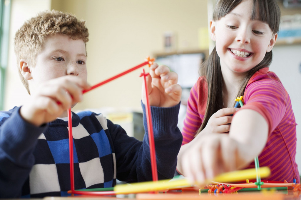 Twee kinderen spelen met een plastic bouwset