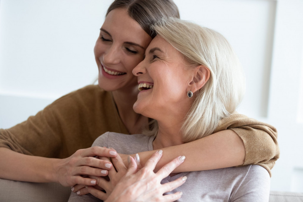 Volwassen dochter omhelst haar moeder