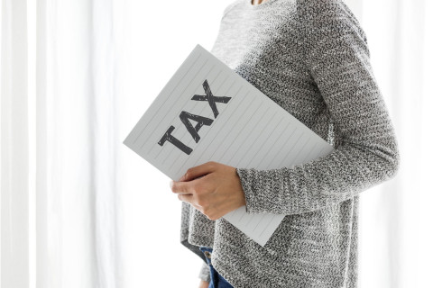 Vrouw met kaft waarop tax staat geschreven
